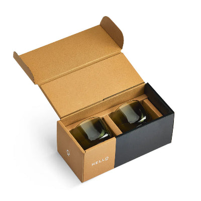 Open cardboard box with a black interior containing two gold-colored items on a white background.