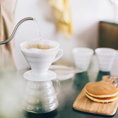 Coffee brewing setup with a filter and coffee grounds on a table.