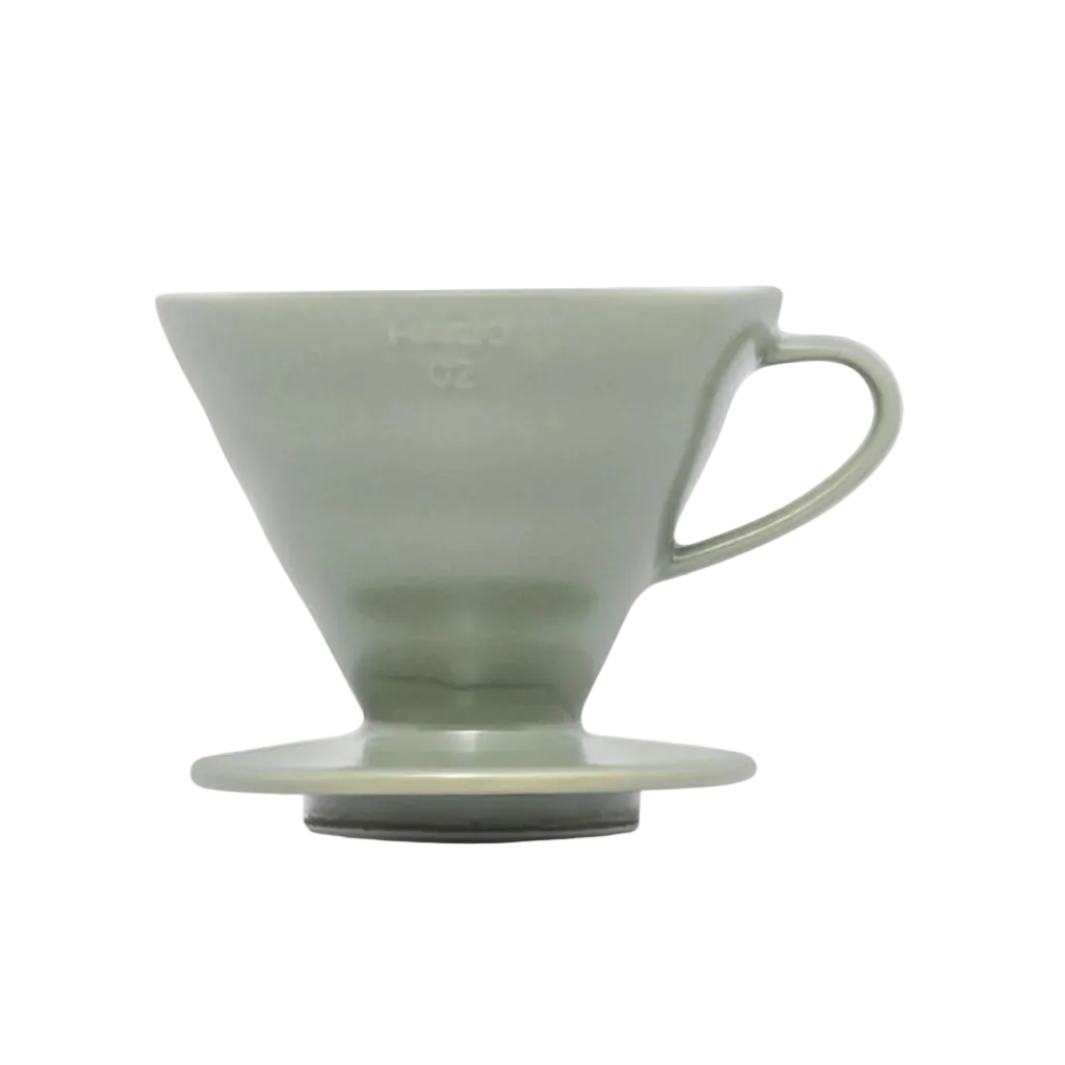 Green ceramic coffee dripper on a white background