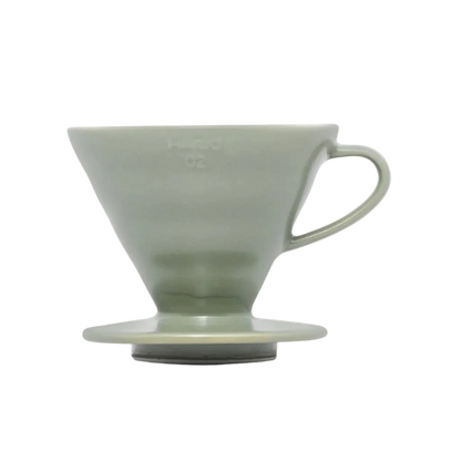 Green ceramic coffee dripper on a white background