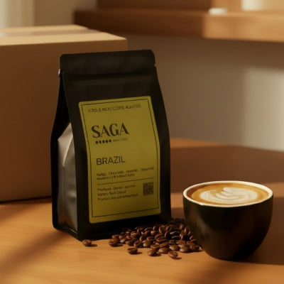 Coffee bag labeled 'SAGA' with coffee beans and a cup of coffee on a wooden surface.