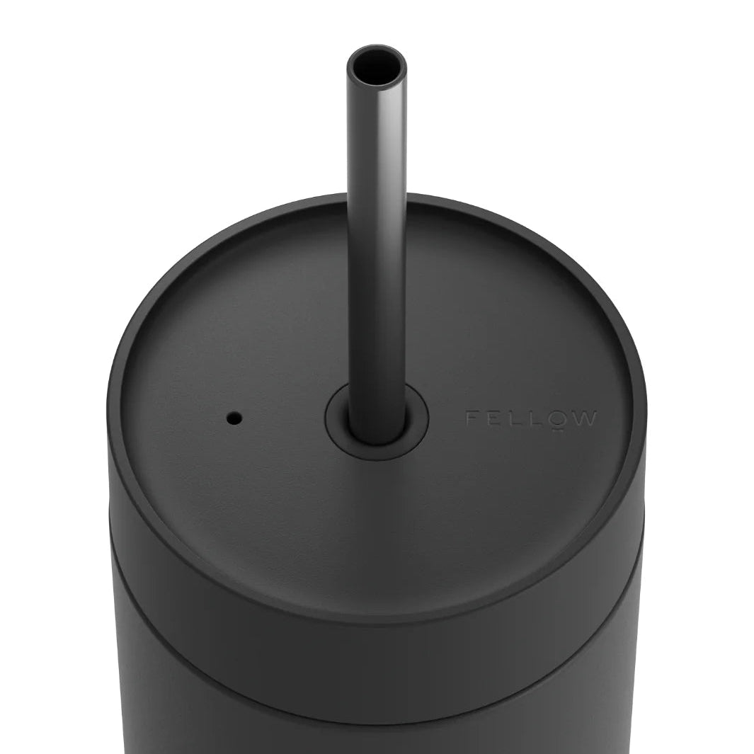 Black tumbler with straw on a white background