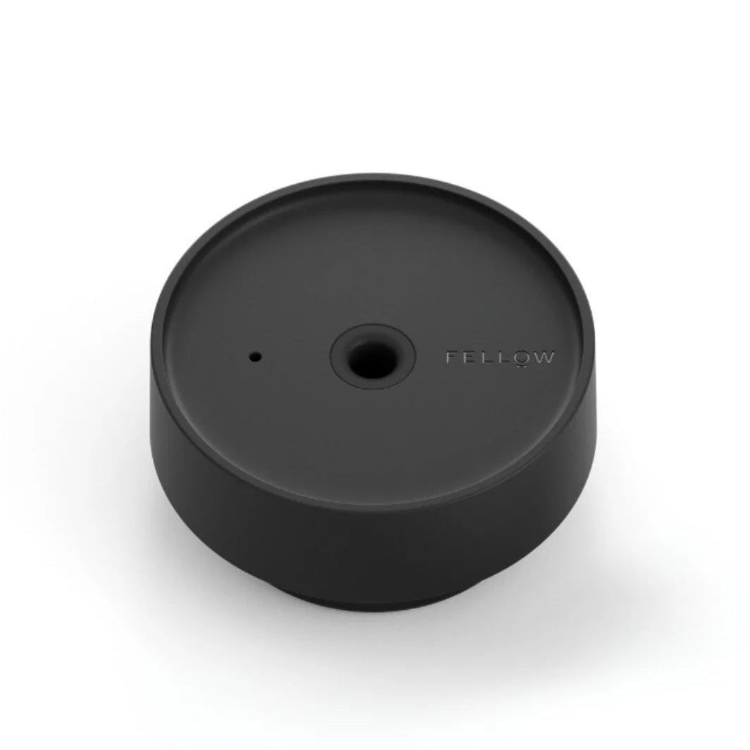 Black circular object with a brand logo on a white background