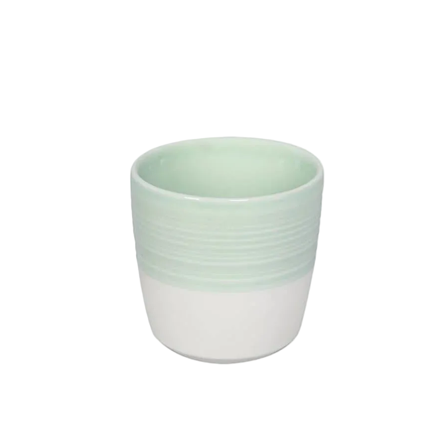 A small ceramic cup with a two-tone design, featuring a pale mint green upper half with horizontal ridges and a white lower half, set against a plain white background.