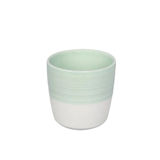 A small ceramic cup with a two-tone design, featuring a pale mint green upper half with horizontal ridges and a white lower half, set against a plain white background.