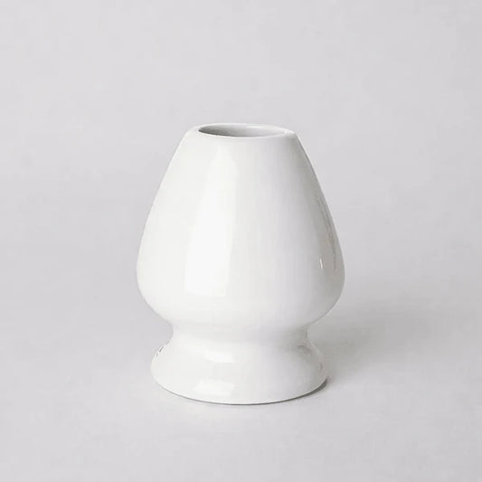 White ceramic Matcha whisk stand on a light gray background
